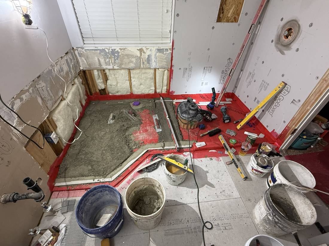 Final mortar bed being floated over the membrane in the shower