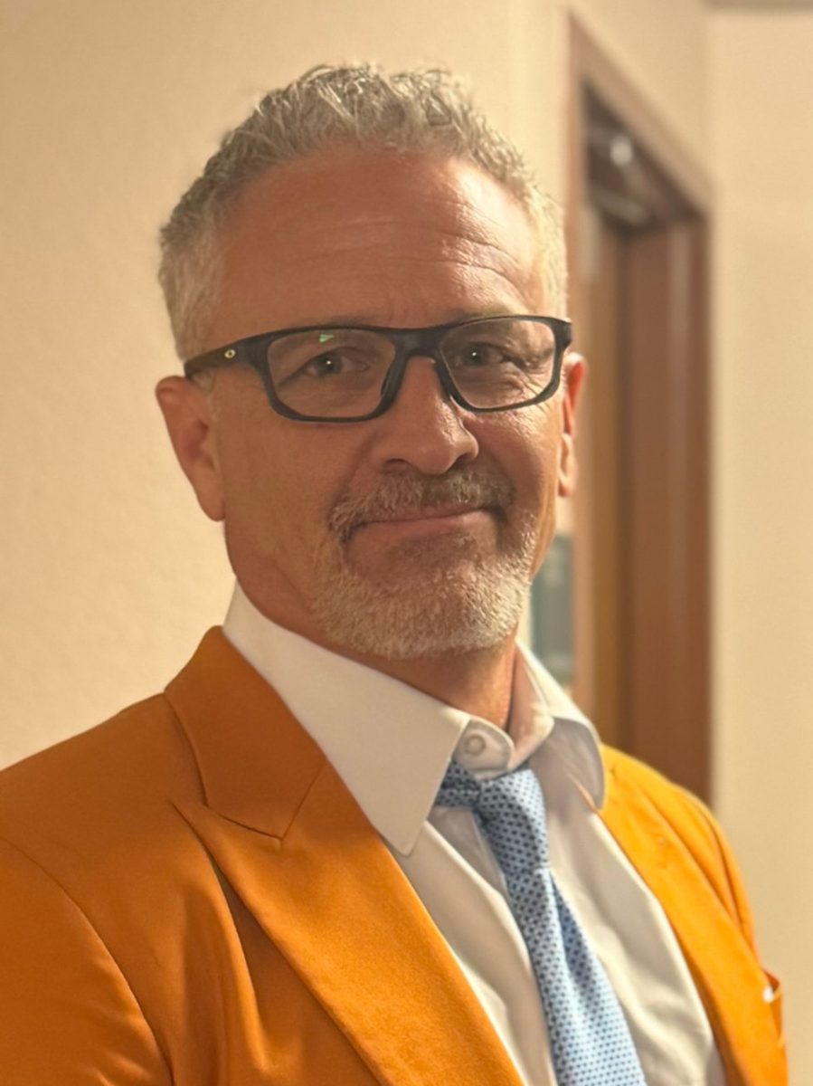 Shawn, owner of Pueblo Stone, in an orange jacket and glasses